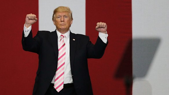Stand up: President Donald Trump walks off the stage after speaking in Alabama.