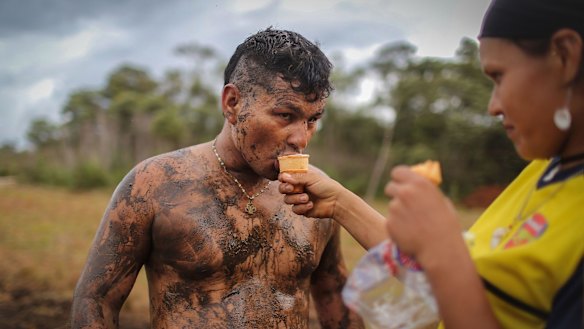 FARC rebel couple Camila gives her boyfriend Cristobal an ice cream as he plays soccer in the mud following a guerrilla conference in the remote Yari plains on Sunday.