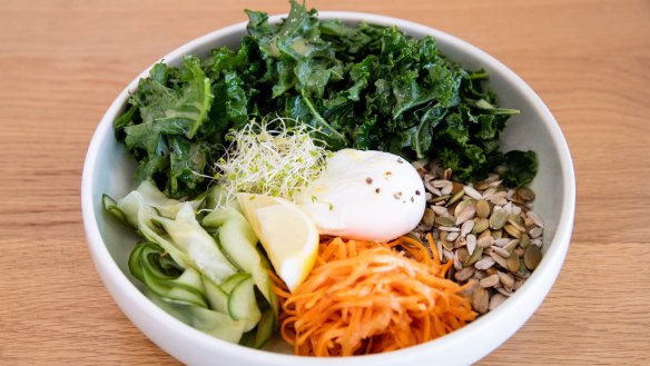 The breakfast bowl is served with poached egg, brown rice, raw kale and quinoa. 