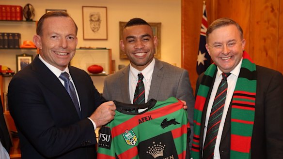 Former prime minister Tony Abbott presents a South Sydney NRL Jersey to Nathan Merritt.