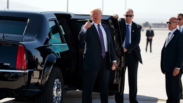 President Donald Trump talks to reporters before getting into his vehicle at Las Vegas McCarran International Airport to go meet with victims of the mass shooting.