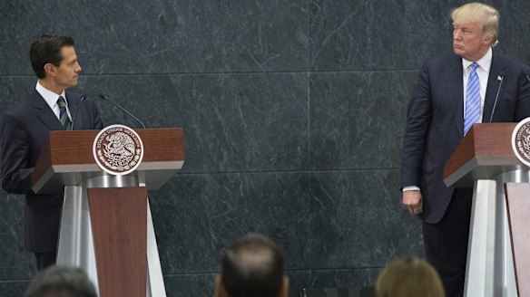 Mexican President Enrique Pena Nieto, left, looks at Donald Trump during a joint conference in Mexico City.