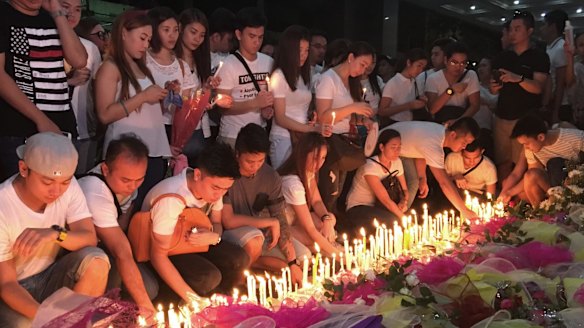 Mourners light candles and lay flowers in front of a memorial outside the casino.