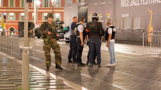 Police officers and a soldier stand by the sealed-off area where the attack took place.