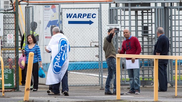 Laid-off Ford workers leaving the Broadmeadows plant at the end of their last shift, some taking selfies. 