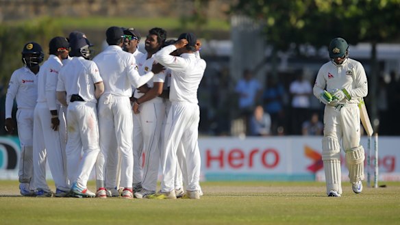 Down and out: Usman Khawaja trudges off as the Sri Lankans celebrate on day two of the second Test.