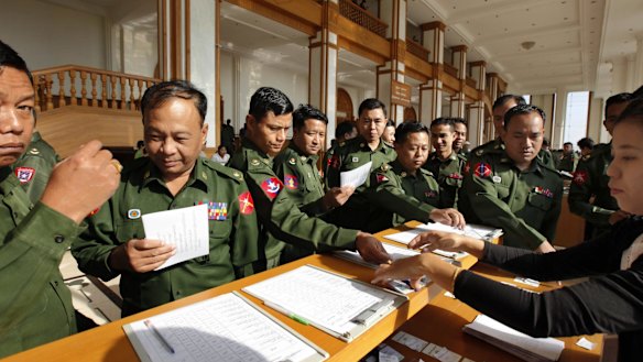 Myanmar military lawmakers sign in to attend the final session of Myanmar's outgoing Parliament as it ended its five-year term on Friday.