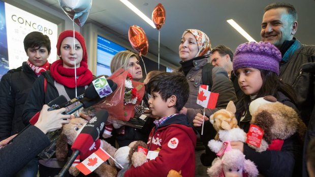 Tima Kurdi, third from left, meets her brother, Mohammad Kurdi, right, and his family, who have escaped conflict in Syria, at Vancouver International Airport.