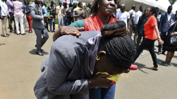 Grief: A relative is assisted by Red Cross staff as bodies of the students killed in the attack arrive at Chiromo Mortuary in Nairobi.