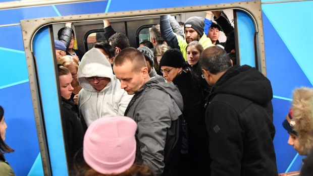 Passengers try to squeeze aboard a packed train during Thursday's rail meltdown.