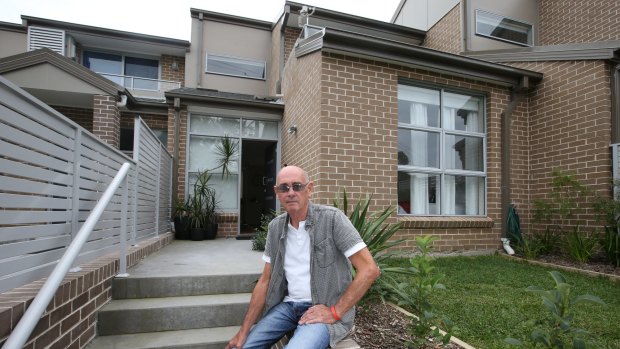 A $70,000 dilemma: John Barnes on the steps of a town house he purchased off the plan in Berowra Heights.