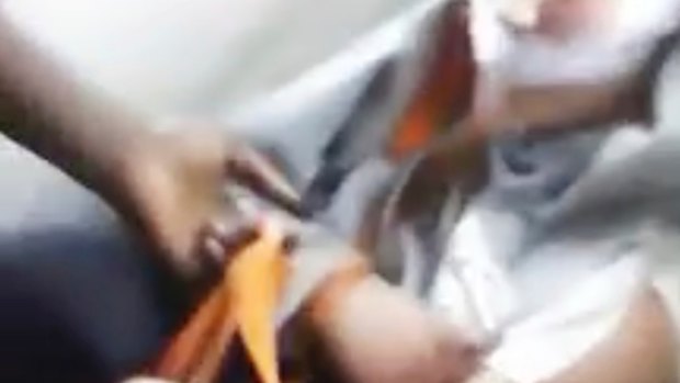 This image from the video a frame shows the man with his mouth taped shut.