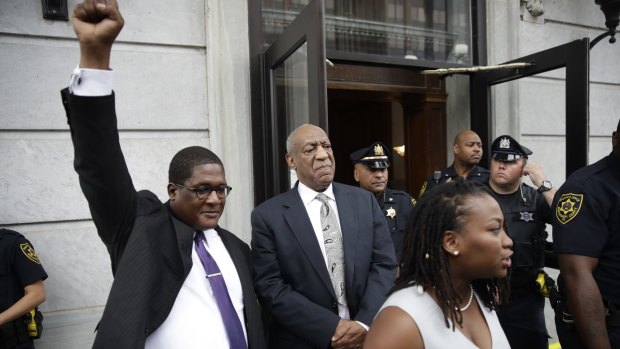 Andrew Wyatt raises his fist and Ebonee Benson (right) prepares to address the media as Bill Cosby exits court after a mistrial was declared in Norristown, Pennsylvania, on June 17.