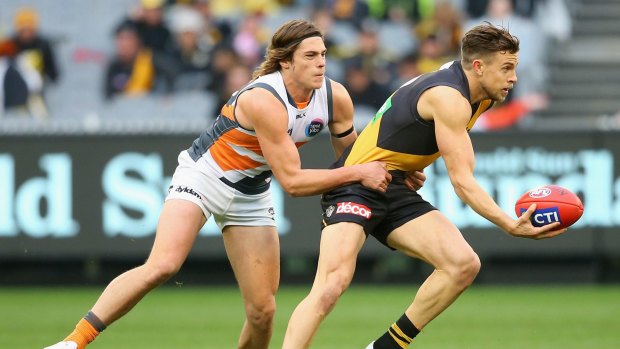 Brett Deledio tries to get out of the grasp of Jack Steele of the Giants during Saturday's match.
