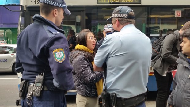 Police question a young woman outside the Sydney Apple Store.