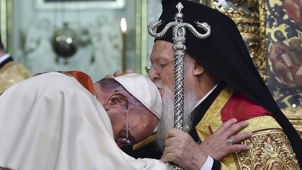 Ecumenical Patriarch Bartholomew I, right, kisses Pope Francis' head during an ecumenical prayer at the Patriarchal Church of St George in Istanbul in 2014.