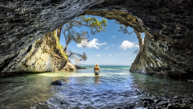 Man enjoying the sun from a sea cave in Jervis Bay, NSW.