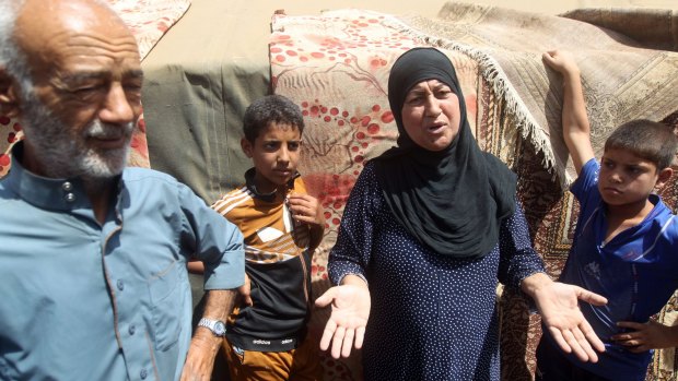 Iraqi families, who fled the city of Ramadi after it was seized by Islamic State militants, talk to journalists at a camp in Bzeibez, on the south-western frontier of Baghdad on Monday. 