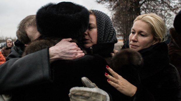 Members of the Nemtsov family embrace as people bring flowers to the grave of the slain Russian opposition figure. 
