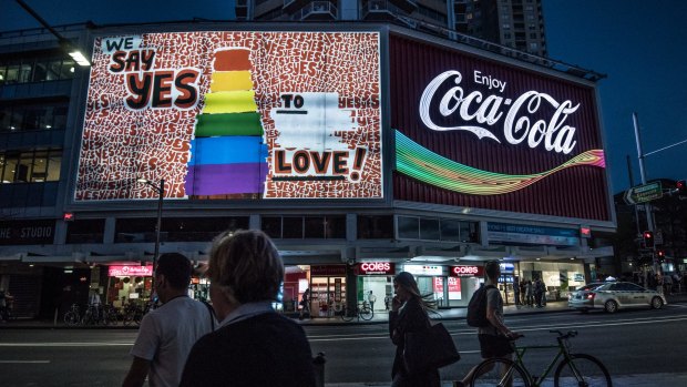 The Coca-Cola sign in Sydney's Kings Cross lights up in rainbow colours.