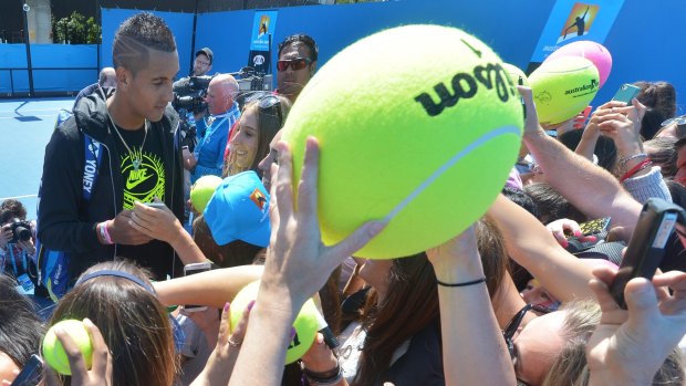 Nick Kyrgios signs autographs after his practice session on Monday.