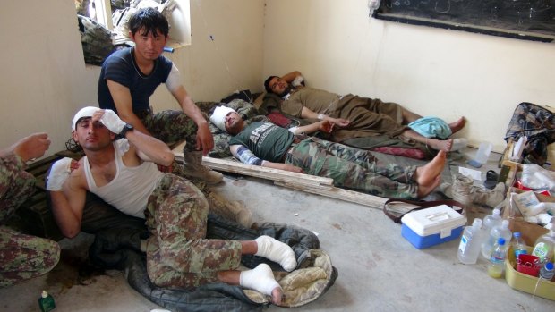 "Friendly fire": Wounded Afghan soldiers lie on the ground as they receive treatment. 