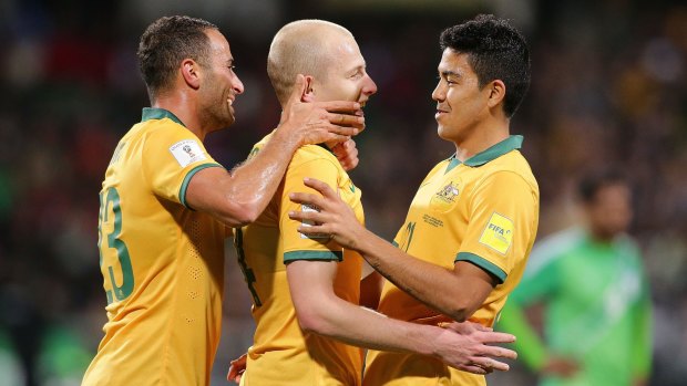 Aaron Mooy of Australia celebrates closely with teammates after scoring.