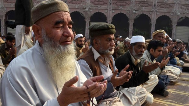 Pakistani Muslims pray for children and teachers killed by Taliban militants in the school attack.