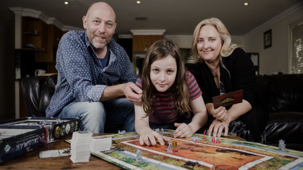 Canberra's littlest heavy metal guitar player Callum McPhie with parents Doug McPhie and Melissa Freeman at their north Canberra home. They love playing board games together.