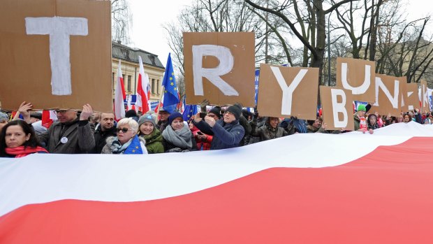 People hold placards with letters forming the word "Tribunal" as thousands gather in front of the Constitutional Tribunal in Warsaw to protest against moves that have paralysed the nation's highest court.