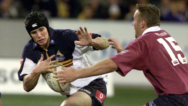 Brumbies great Stephan Larkham tries to palm off former Reds star Chris Latham in a Super Rugby semi-final in 2001.