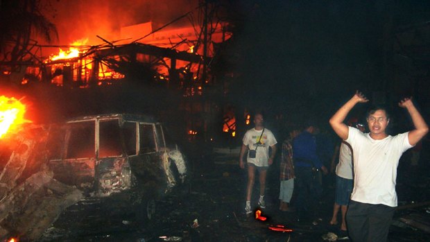 October 13, 2002: residents and foreign tourists evacuate the scene of a bomb blast in Bali, Indonesia.