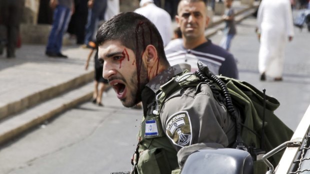 An injured Israeli border policeman reacts during a confrontation with Palestinians outside the Old City in Jerusalem on Friday.