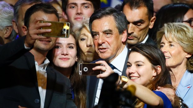 Francois Fillon poses for selfies during an election rally last month.