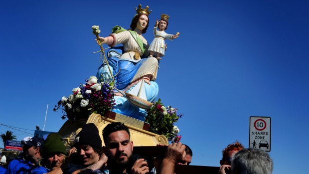 Fishermen carry a statue of the Madonna as part of the Blessing of the Fleet at The Sydney Fish Market.