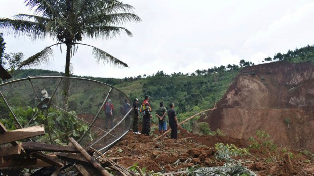 Rescuers search for victims in a neighborhood hit by a landslide in the village of Banaran, Ponorogo, East Java, Indonesia.