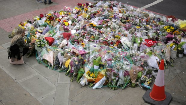 A woman looks at a floral tribute near London Bridge, where eight people died and dozens were seriously injured.