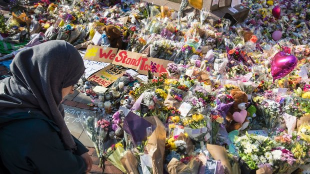 A woman looks at the floral tributes and messages left for the victims of Monday's concert blast.