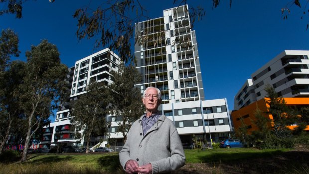 Parkville resident Joe Edmonds in front of an 11-level tower on the former Commonwealth Games Village site. New rules would allow towers up to double its height. 