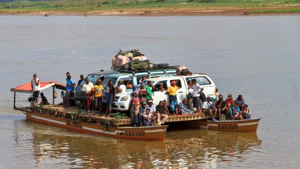 Tourists with their off road vehicle and locals take the ferry during an excursion in Belo Tsiribihina.