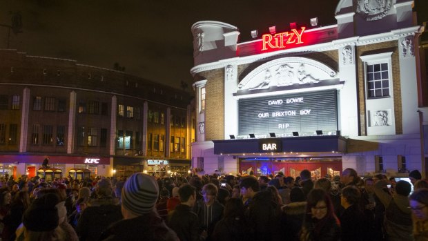 Members of the public gather outside the Ritzy Cinema in Brixton to pay tribute to David Bowie on Monday.
