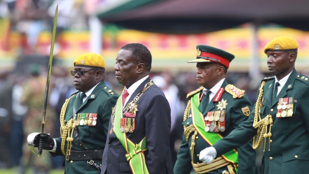 Emmerson Mnangagwa, with Army General Constantino Chiwenga, second right, inspects the military parade.
