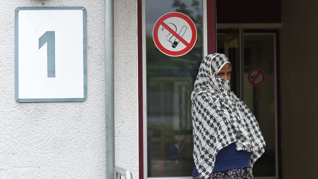 A woman stands outside the refugee registration camp in Friedland, central Germany, on Tuesday. 