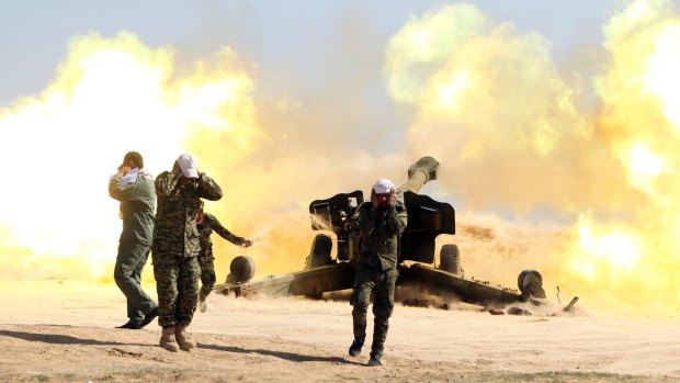 Volunteer Shiite fighters fire an artillery canon near the city of Tikrit.