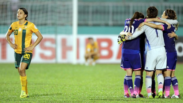 Japan celebrates as a disapoointed Sam Kerr heads off the pitch.