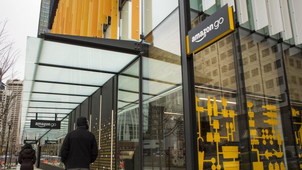 Pedestrians walk past the new Amazon.com grocery store in Seattle, Washington.