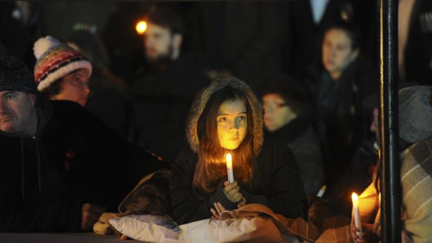 A girl holds a candle at the Anzac Day dawn service.
