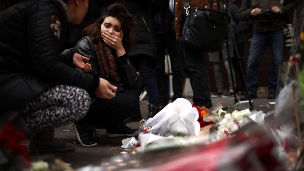 A woman places flowers near the scene of the Bataclan Theatre terrorist attack.