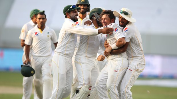 Pakistan players celebrate with Yasir Shah, second right, after the dismissal of England's Adil Rashid.