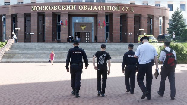 Police officers walk towards the Moscow Regional Court.
